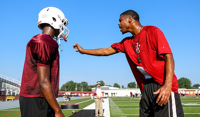 Liberty-Eylau safeties coach Marcus Peters explains to a player how to block and get past the defense during the Leopards' practice Wednesday at Harris Field. The Leopards have moved practice up to two-a-days this week to prepare for the upcoming football season. (Staff photo by Hunt Mercier)
