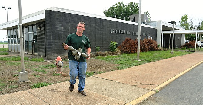 Matt Haller carries a backflow prevention device back to his vehicle Aug. 8, 2019, after picking it up at the airport terminal in North Jefferson City. Haller works for Central Missouri Plumbing which had loaned public works crews the device for when they were washing away the mud and debris after the floodwater receded. City staff is recommending the Jefferson City Memorial Airport terminal be demolished after seeing the damage that resulted from this most recent flood. 