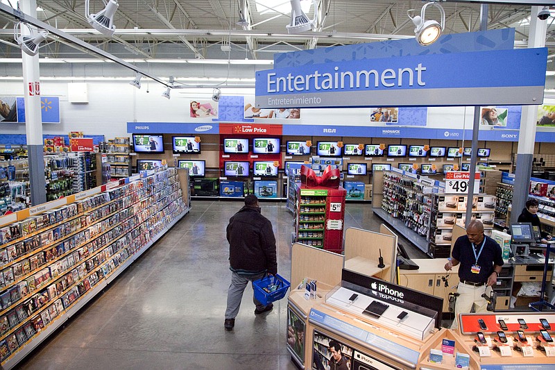 FILE = In this Dec. 15, 2010 file photo, a view of the entertainment section of a Wal-Mart store is seen in Alexandria, Va.  Walmart is taking down all signs and displays from its stores that depict violence, following a mass shooting at its El Paso, Texas location that left 22 people dead. The retailer, according to an internal memo, instructed employees to turn off or unplug any video game consoles that show  violent games, as well as ensure that no movies depicting violence are playing in its electronics departments.   (AP Photo, File)