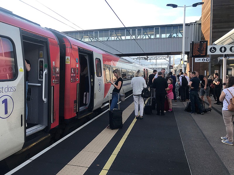 Passengers wait for news during travel disruption on the East Coast mainline at Peterborough Station, Peterborough, England, Friday, Aug. 9, 2019. London and large chunk of the U.K. were hit with a power cut Friday afternoon that disrupted train travel and snarled rush-hour traffic. U.K. Power Networks, which owns and maintains electricity cables in London and southern England, said a network failure at power supplier National Grid was affecting its customers.  (Martin Keene/PA via AP)