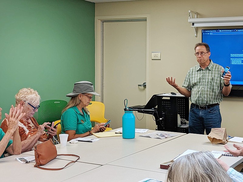 Master Gardner Peter Sutter, right, helps Fulton Garden Club members including Virginia Starke (left) and Christa Daume navigate helpful gardening apps.