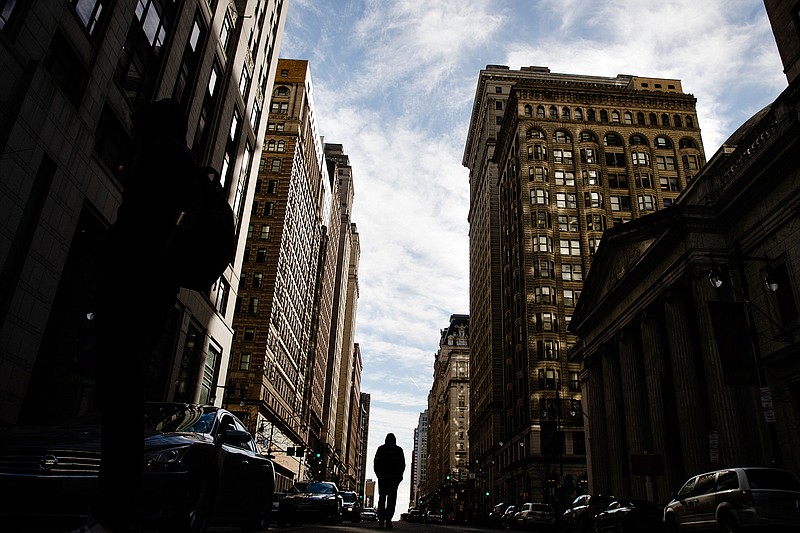 In this Feb. 8, 2019, file photo a pedestrian walks down South Broad Street in Philadelphia. Bounce back from a personal loan rejection by building your credit score, growing your income and paying off debt. Shop around and apply at lenders whose minimum qualifications you meet. (AP Photo/Matt Rourke, File)