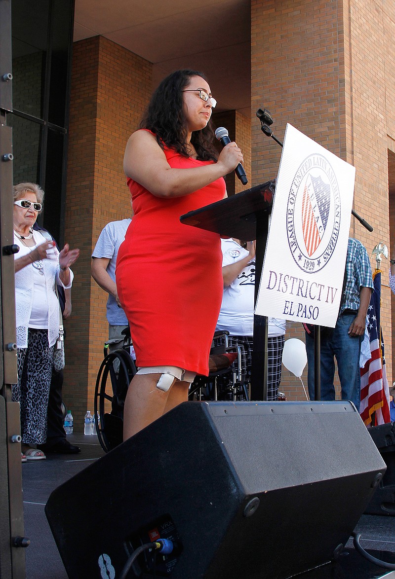 Jessica Coca Garcia stands in front of her wheelchair addressing those gathered at the League of United Latin American Citizens' "March for a United America" Saturday, Aug. 10, 2019 in El Paso, Texas.   More than 100 people marched through the Texas border denouncing racism and calling for stronger gun laws one week after several people were killed in a mass shooting that authorities say was carried out by a man targeting Mexicans.  Garcia and her husband were injured during the mass shooting. (AP Photo/Cedar Attanasio)