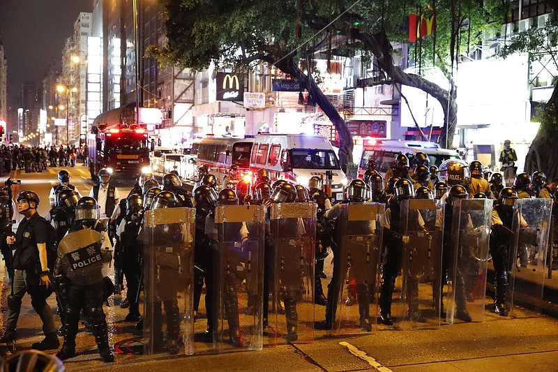 Police form up near the Tsim Sha Tsui police station in Hong Kong on Saturday, Aug. 10, 2019. Hong Kong is in its ninth week of demonstrations that began in response to a proposed extradition law but have expanded to include other grievances and demands for more democratic freedoms. (AP Photo/Vincent Thian)