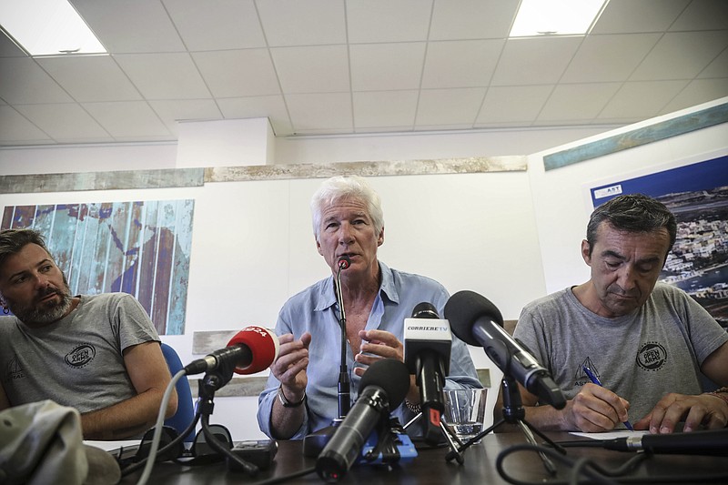 Actor Richard Gere gestures as he speaks during a press conference he held along with Open Arms founder Oscar Camps, in the island of Lampedusa, Southern Italy, Saturday, Aug. 10, 2019, the day after he visited the Spanish humanitarian ship that has been stuck at sea with 121 migrants on board for over a week, after Italy and Malta have denied it entry. The Open Arms boat has rescued 39 more migrants on Saturday morning. (AP Photo/Valerio Nicolosi)