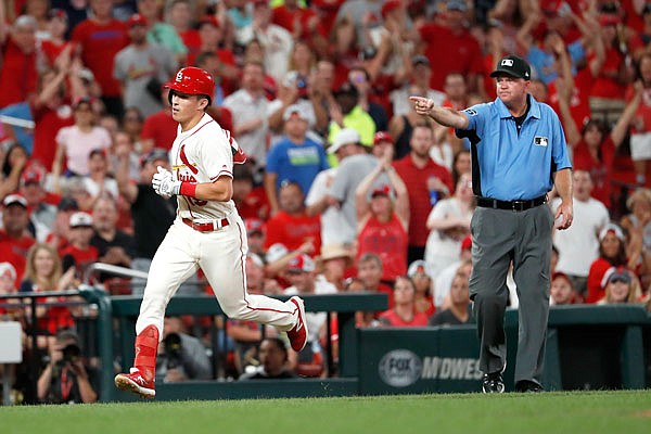 Third base umpire Ron Kulpa motions for Tommy Edman of the Cardinals to head home after Edman hit a double then was able to score on a throwing error by Pirates shortstop Kevin Newman during the sixth inning of Saturday night's game at Busch Stadium.