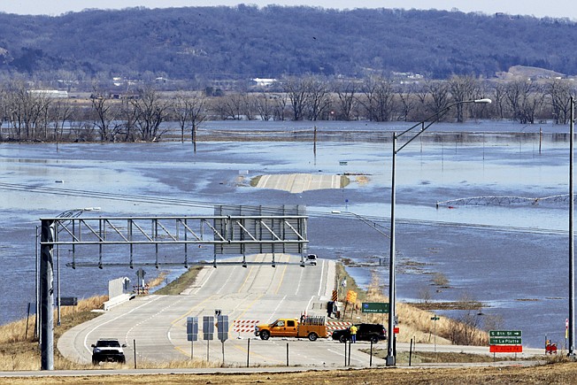 Nebraska Department of Roads crews block the flooded Highway 34 that connects Platteview, Neb., to Interstate 29 on March 16 in Iowa. 