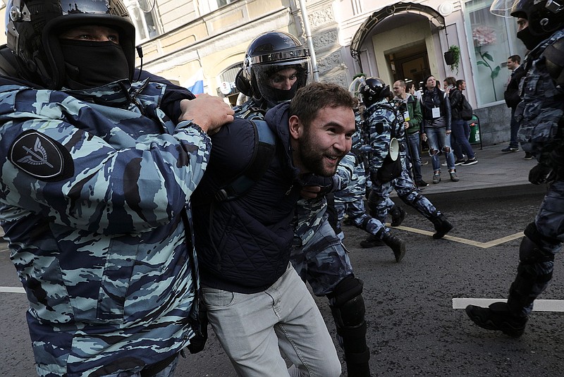 Police detain a protester during a protest in Moscow, Russia, Saturday, Aug. 10, 2019. Tens of thousands of people rallied in central Moscow for the third consecutive weekend to protest the exclusion of opposition and independent candidates from the Russian capital's city council ballot. (AP Photo)