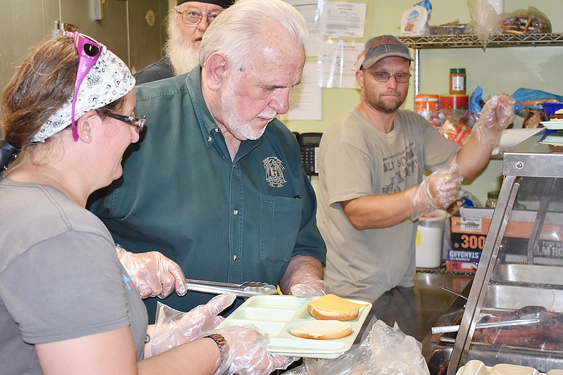 From left, Christina Ward, Mike Kufrovich and Tom Ward serve meals Sunday at the Salvation Army. Area Christian Motorcyclists Association members provided food for the body and soul for the second year with their hot dog and hamburger barbecue. 