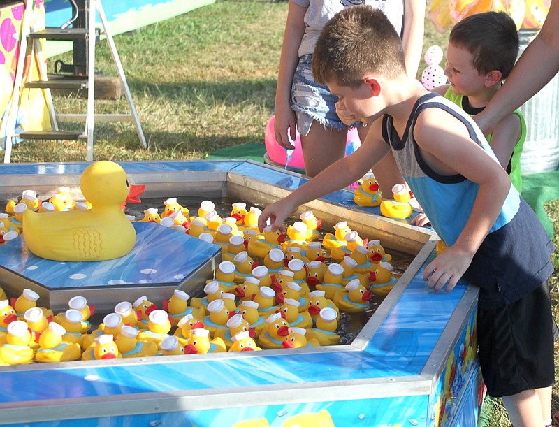 Mason, 5, and Carter Combs, 3, carefully select a rubber ducky Aug. 10, 2019, at the Moniteau County Fair in hopes of winning a toy monster truck.