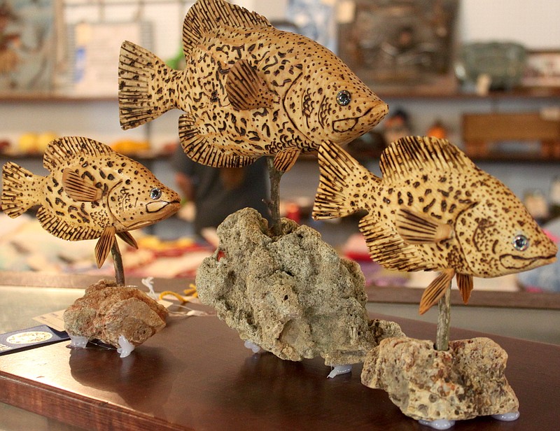 Three wooden fish swim peacefully atop a cabinet Aug. 10, 2019, at the Moniteau County Fair's Art Show in Centennial Hall. The piece was made by Bob Staton of California.