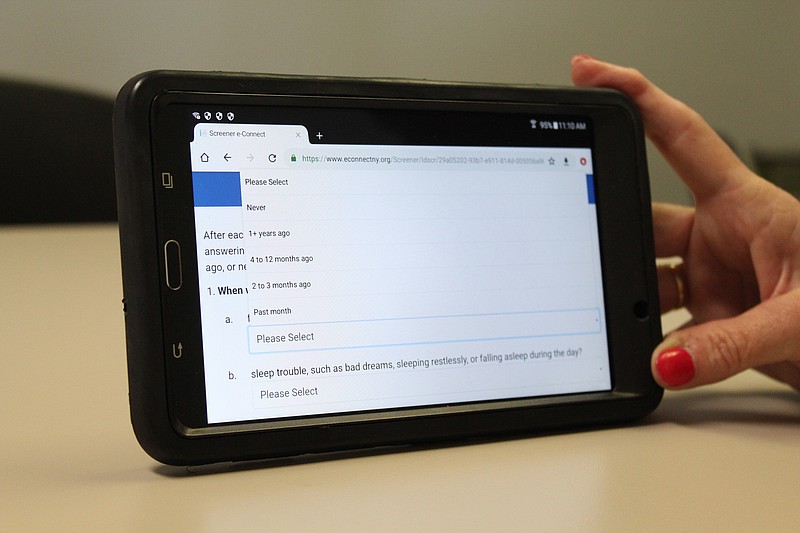 An Albany County probation official on Monday, Aug. 5, 2019, holds up a tablet used to conduct the e-Connect program, at the Albany County Probation Department office. The project screens young offenders for risk of suicide as a way to connect them with mental health services. (AP Photo/Ryan Terinelli)