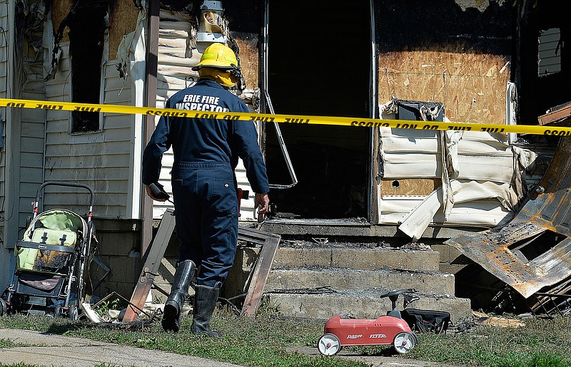 Erie Bureau of Fire Inspector Mark Polanski helps investigate a fatal fire on Sunday, Aug. 11, 2019, in Erie, Pa. Authorities say the early-morning fire in northwestern Pennsylvania claimed the lives of multiple children and sent another person to the hospital.