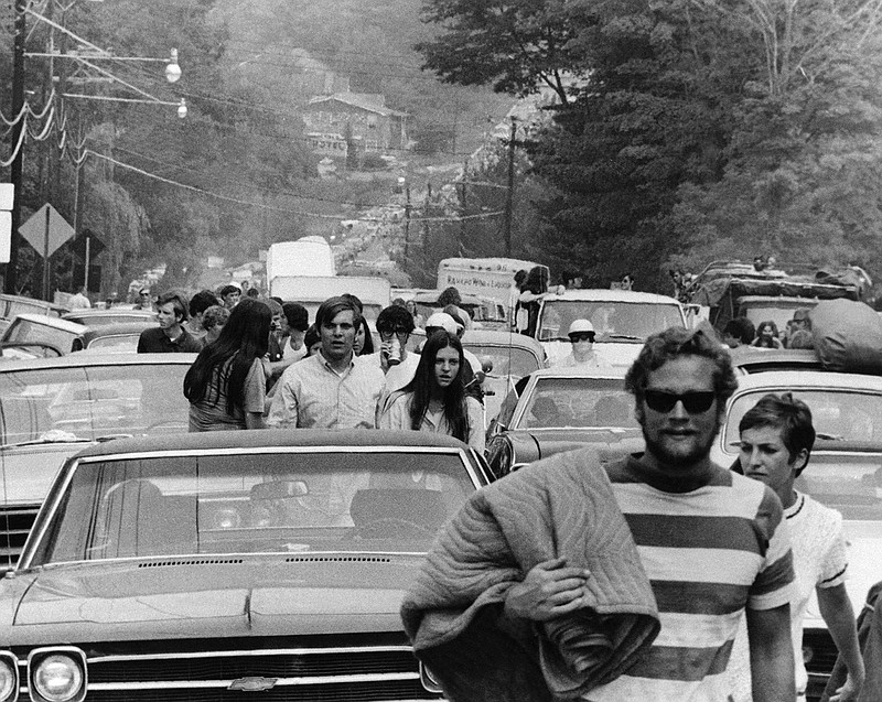 FILE - In this Aug. 15, 1969 file photo, concert goers abandon their trucks, cars and buses as thousands try to reach the Woodstock Music and Art Festival at White Lake in Bethel, N.Y. Although Arlo Guthrie famously announced from the festival stage that "The New York State Thruway is closed, man," that wasn't exactly the case. Police closed at least one thruway exit east of the festival to stem the source of a blockbuster traffic jam around the site. The New York Daily News reported on Aug. 16 that cars were being delayed by as much as eight hours between New York City and the concert site - a distance of less than 100 miles.