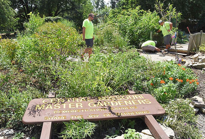 The sign that designates the area as Central Missouri Master Gardeners Demonstration Gardens now lies on the ground after recent flooding damaged the area. The organization plans to repair the greenhouses and gardens as conversations are ongoing about potentially relocated to a different park.