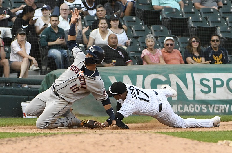 Houston Astros' Yuli Gurriel (10) slides safely into third base as Chicago White Sox third baseman Ryan Goins (17) makes a late tag during the eighth inning of game one of a baseball doubleheader, Tuesday, Aug. 13, 2019, in Chicago. (AP Photo/David Banks)