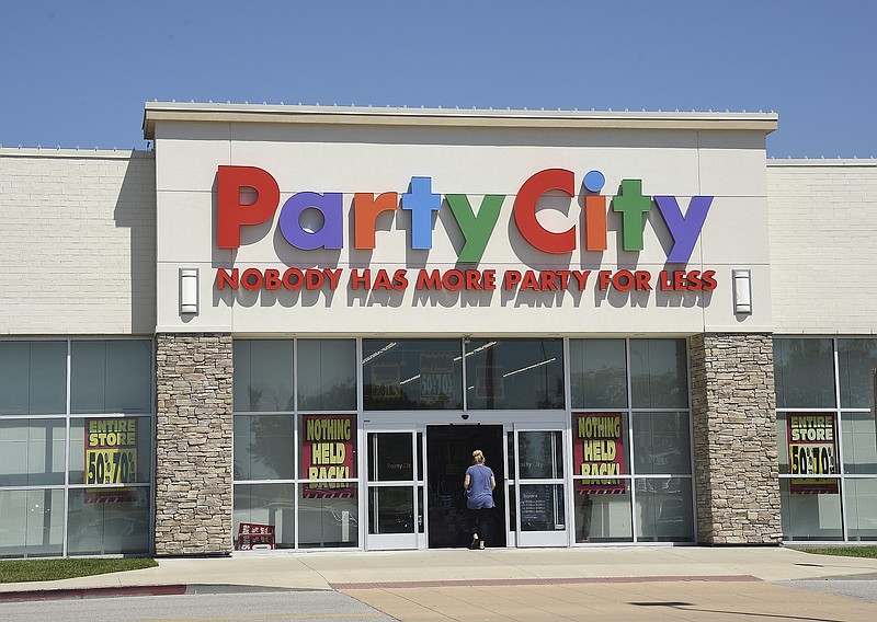 Julie Smith/News TribuneA customer enters Party City in hopes of finding discounted items as the Capital Mall store will soon be closing. Signs in the windows boasting of large discounts and nothing being held back are used in an effort to move out the stock. 