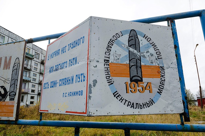 This photo taken on Oct. 7, 2018, shows a billboard that reads "The State Central Navy Testing Range" near residential buildings in the village of Nyonoksa, northwestern Russia. The Aug. 8, 2019, explosion of a rocket engine at the Russian navy's testing range just outside Nyonoksa led to a brief spike in radiation levels and raised new questions about prospective Russian weapons. (AP Photo/Sergei Yakovlev)