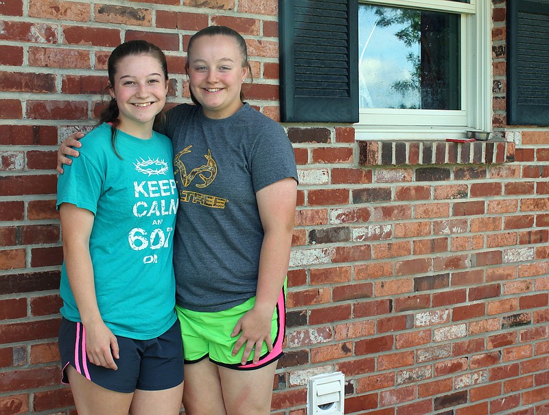 <p>Rebecca Martin/News Tribune</p><p style="text-align:right;">Cassie Pruitt, left, and Annie Pruitt smile outside their home near Holts Summit. The sisters helped at the distribution center at Capital West Christian Church following the tornado.</p>