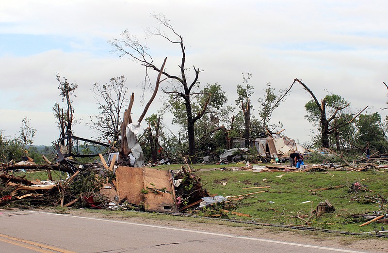 Residents clean up debris at the Twin Bridges Mobile Home Village on Heritage Highway on May 23, 2019, after a tornado hit the area south of Jefferson City late May 22.