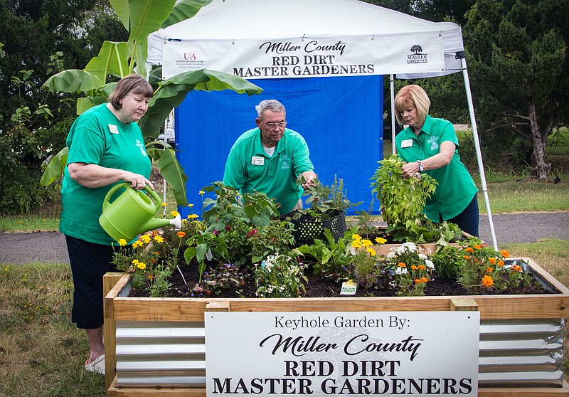 Clyde Davis, center, with the Miller County Red Dirt Master Gardeners Association, and two other association members water a keyhole garden recently established near the Gateway Farmers Market in Texarkana, Ark. Association members will hold a demonstration at the garden site Saturday. Anyone interested in being part of the association or in taking gardening classes is encouraged to attend. (Submitted photo by Clyde Davis)
