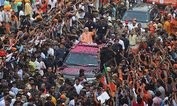 In this April 25, 2019 file photo, Indian Prime Minister Narendra Modi, center, waves to the crowd during a political campaign road show in Varanasi, India. Modi, who first became prime minister in 2014, has reinforced his power with nearly every election since then. In national voting earlier this year, the BJP took 303 of the 542 seats in the lower house of Parliament.  (AP Photo/Rajesh Kumar Singh, File)