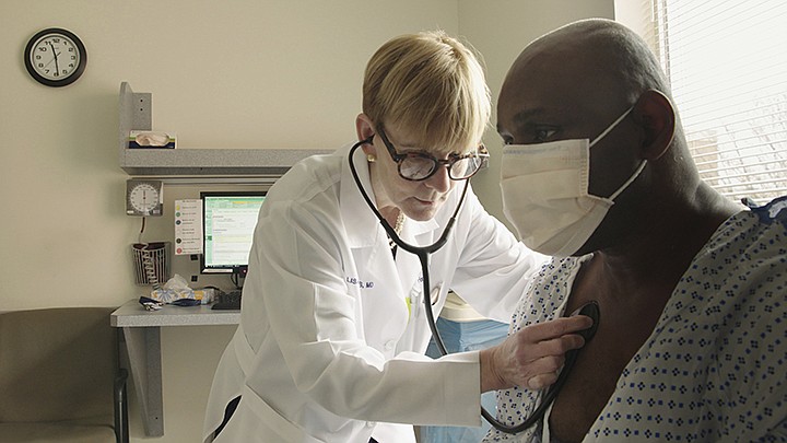 This photo provided by Netflix shows Dr. Lisa Sanders examining a patient in a scene from the new Netflix series "Diagnosis," which transports Sanders' column from the pages of The New York Times to television. The show, which is available starting Friday, Aug. 16, 2019, harnesses the internet and social media to diagnose unusual cases.  (Netflix via AP)