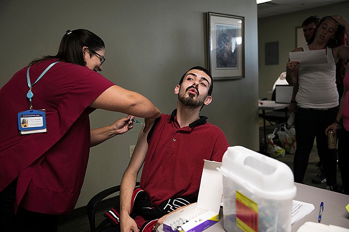 Summit County Public Health nurse Rachel Flossie gives a hepatitis A vaccination to Robert Wolf, 24, during a South Street Ministries program in Akron, Ohio, on July 23, 2019. (Maddie McGarvey for KHN/TNS)