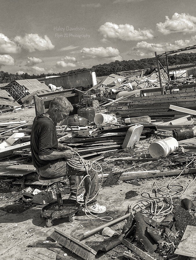 <p>Courtesy of Haley Davidson</p><p>Doug Schrimpf, of Doug Schrimpf Construction, picks up his tools, scattered among debris at Braun Storage off U.S. 54 after the May 22 tornado.</p>