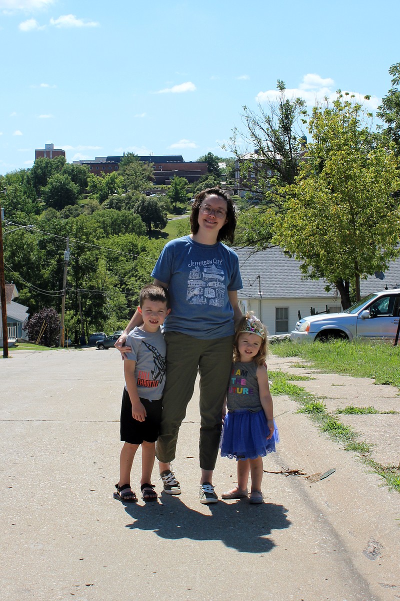 Rebecca Martin/News Tribune 
Cassie Huckabay, with her children, Henry Huckabay, 6, and Eleanor Huckabay, 3, stand on Jackson Street where they could see their own home from atop the hill after the May 22, 2019, tornado knocked down trees throughout the area. Huckabay matched up families in need with families who wanted to "adopt" them after the tornado.