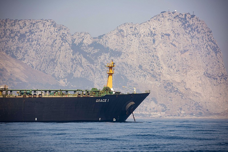 A view of the Grace 1 supertanker is seen backdropped by Gibraltar's Rock, as it stands at anchor in the British territory of Gibraltar, Thursday, Aug. 15, 2019, seized last month in a British Royal Navy operation off Gibraltar.  The United States moved on Thursday to halt the release of the Iranian supertanker Grace 1, detained in Gibraltar for breaching EU sanctions on oil shipments to Syria, thwarting efforts by authorities in London and the British overseas territory to defuse tensions with Tehran.(AP Photo/Marcos Moreno)