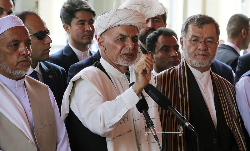 Afghanistan's President Ashraf Ghani, center, speaks after offering Eid al-Adha prayers at the presidential palace in Kabul, Afghanistan, Sunday, Aug. 11, 2019. Ghani is urging the nation to determine its fate without foreign interference as the United States and the Taliban appear to near a peace deal without the Afghan government at the table.(AP Photo/Nishanuddin Khan)