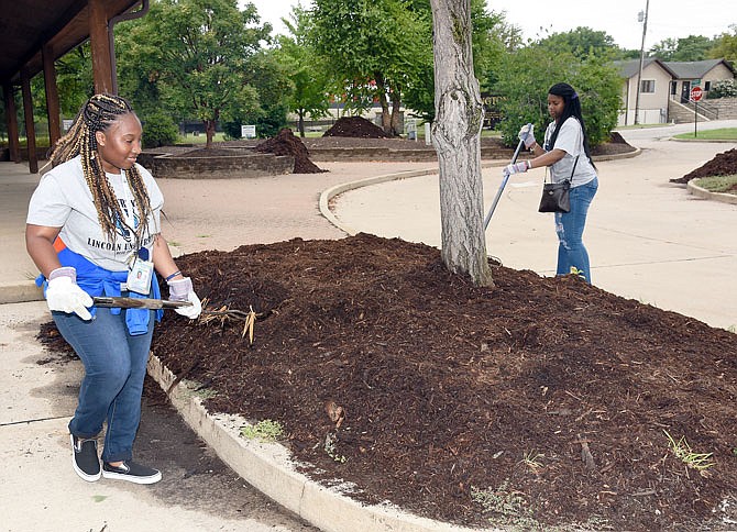 Keirra Wilson, left, and Andronae Johnson spread mulch in one of the islands adjacent Washington Park Ice Arena. They were just two of the several dozen freshmen to participate in Friday's Lincoln University Day of Service in conjunction with the United Way of Central Missouri.