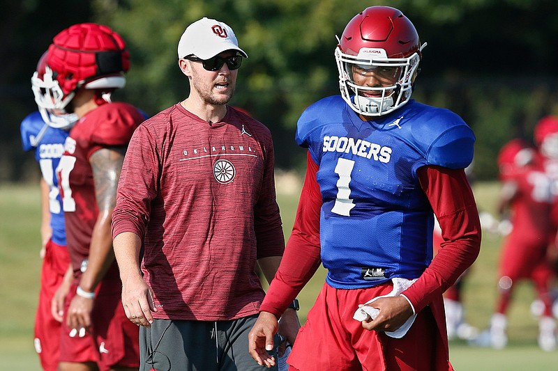 In this Monday, Aug. 5, 2019 file photo, Oklahoma head coach Lincoln Riley watches quarterback Jalen Hurts (1) during an NCAA college football practice in Norman, Okla. Oklahoma quarterback Jalen Hurts is cramming as he prepares for his only year with the Sooners. Before transferring from Alabama, he played in three national title games. (AP Photo/Sue Ogrocki, File)