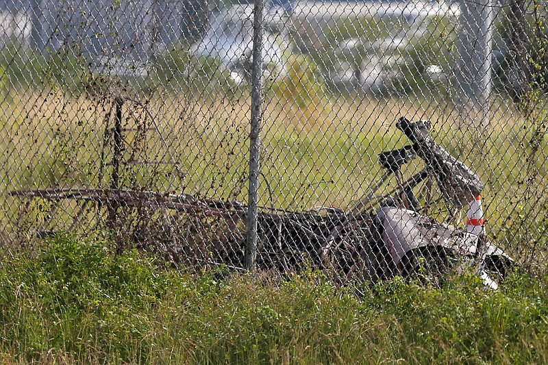 The charred wreckage of a private plane is seen in a field near the Industrial Canal and New Orleans Lakefront airport, in New Orleans, Friday, Aug. 16, 2019. The city said on its "Nola Ready" website that firefighters, emergency medical services and the police responded to the fatal crash Friday afternoon. (AP Photo/Gerald Herbert)