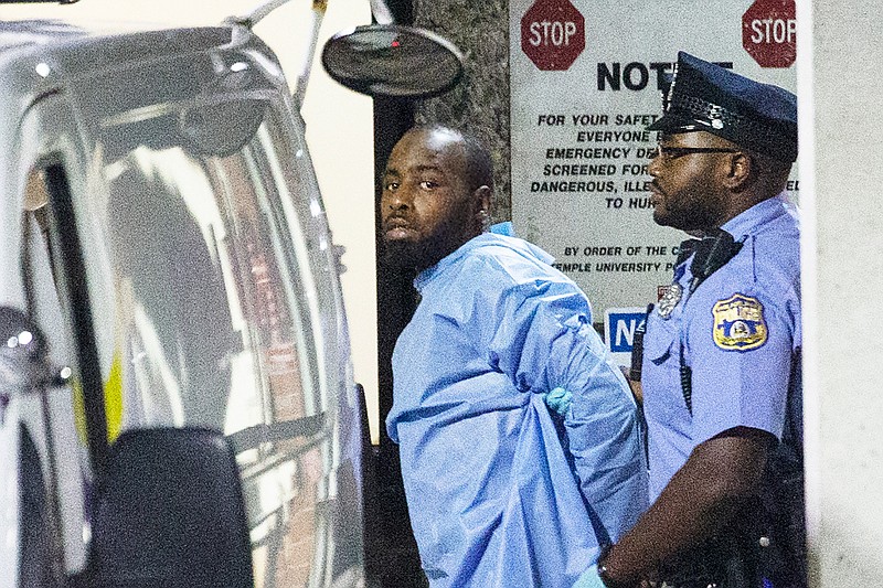 Police take shooting suspect, Maurice Hill, into custody after an hourslong standoff with police, that wounded several police officers, in Philadelphia early Thursday, Aug. 15, 2019.  The standoff started Wednesday afternoon, as officers went to a home to serve a narcotics warrant in an operation "that went awry almost immediately," Philadelphia Police Commissioner Richard Ross said. (Elizabeth Robertson/The Philadelphia Inquirer via AP)