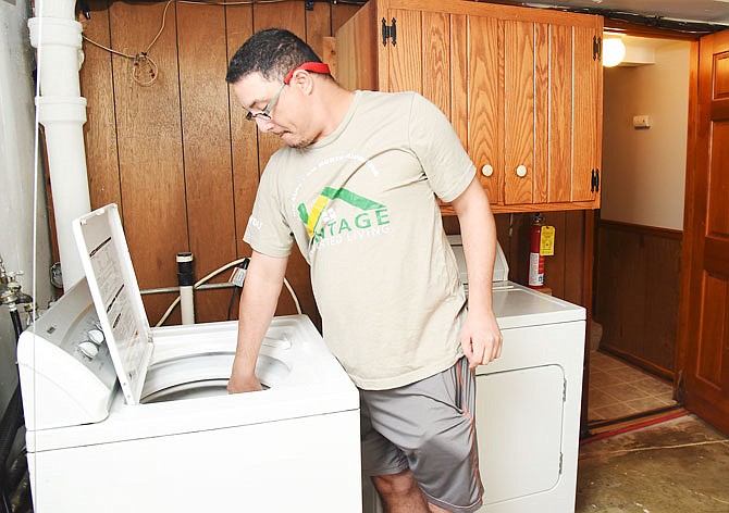 George puts his laundry in the washing machine he recently purchased. He and his roommate, Chris, are able to live independently while sharing a house and responsibilities. There is a direct care staffer who stays with them and, should the need arise, she is there to assist. 