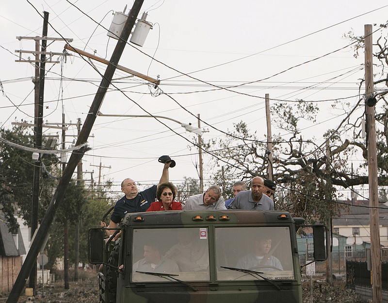 FILE - In this Sept. 12, 2005 file photo, Vice Adm. Thad Allen, left, lifts a downed power line during a tour of the destruction caused by Hurricane Katrina in downtown New Orleans with President Bush, center, Louisiana Gov. Kathleen Babineaux Blanco, second from left, White House Chief of Staff Andrew Card, partially hidden, New Orleans Mayor Ray Nagin, second from right, and Lt. Gen. Russ Honore, right. Blanco, who became Louisiana's first female elected governor only to see her political career derailed by the devastation of Hurricane Katrina, died Sunday, Aug. 18, 2019. She was 76. (AP Photo/Susan Walsh, File)