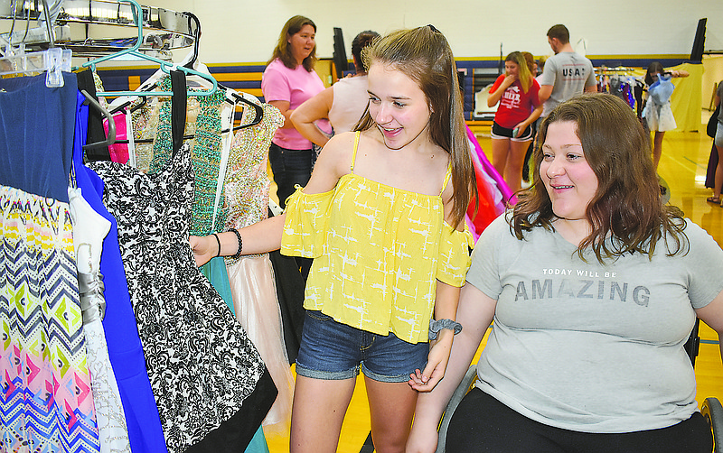 From left, sisters Hayley and Grace Fender shop for dresses Sunday for the Helias homecoming dance at the school's annual Parents Club Formal Resale.