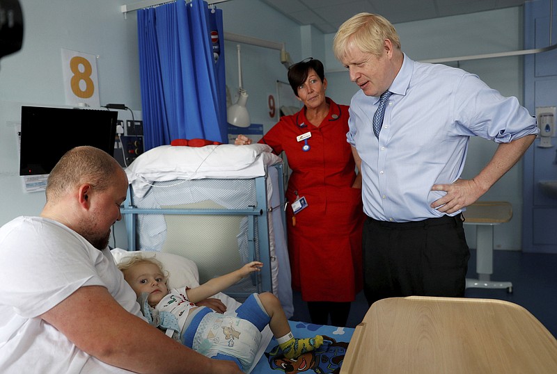 Britain's Prime Minister Boris Johnson meets patients and families during a visit to the Royal Cornwall Hospital in Truro, south-west England, Monday Aug. 19, 2019.   Johnson is under increasing pressure Monday to recall Parliament after leaked government documents warned of widespread problems if the U.K. leaves the European Union without a Brexit withdrawal agreement. (Peter Nicholls/Pool via AP)