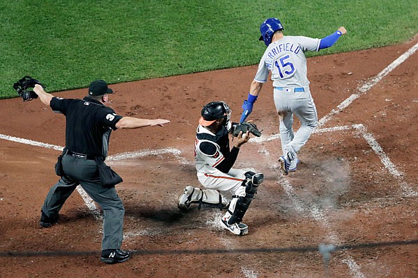 Home plate umpire Sam Holbrook makes the call as Whit Merrifield of the Royals pops up after scoring around the tag of Orioles catcher Pedro Severino during the sixth inning of Monday night's game in Baltimore.