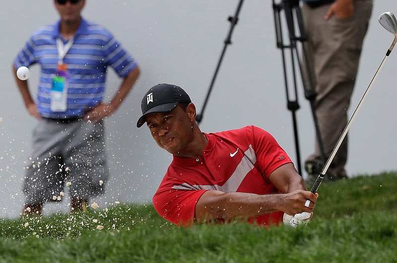  Tiger Woods hits from a bunker on the 13th hole during the final round of the BMW Championship golf tournament on Sunday at Medinah Country Club in Medinah, Ill. 