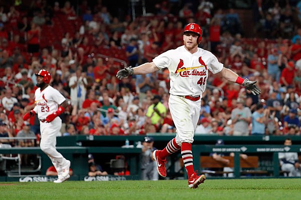 Harrison Bader of the Cardinals celebrates after drawing a bases-loaded walk from Brewers relief pitcher Junior Guerra as teammate Marcell Ozuna (left) comes home to score during the sixth inning of Tuesday night's game at Busch Stadium.