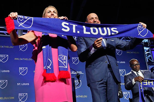 Carolyn Kindle Betz, a member of the ownership group, and Major League Soccer commissioner Don Garber display a St. Louis soccer scarf Tuesday after it was announced St. Louis would be getting an expansion franchise in the 2022 season.
