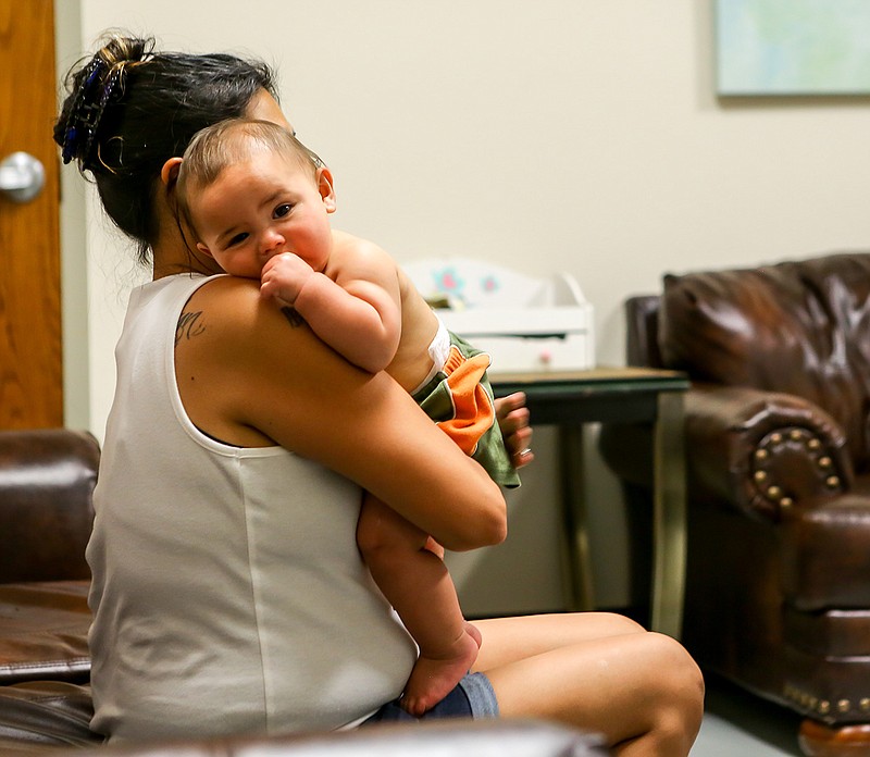 Joylyn Ethridge holds her son Orion in the lounge to cool off from the heat Wednesday at The Salvation's Army Center of Hope in Texarkana, Arkansas. Local nonprofits in the area are providing water, bug spray and cooling stations to help with the excessive heat.