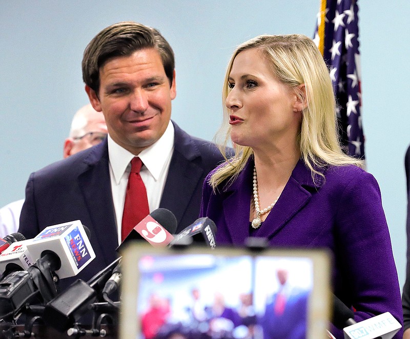 Florida governor Ron DeSantis listens to Florida Secretary of State Laurel Lee during the announcement that Florida will join 28 other states to implement a database to improve voter roll accuracy, during a press conference at the Orange County Supervisor of Elections Office in Orlando, Fla., Wednesday, Aug. 21, 2019.  (Joe Burbank/Orlando Sentinel/TNS) 