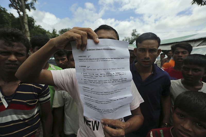 A Rohingya refugee displays to journalists a demand letter about Rohingya repatriation at Nayapara camp in Cox's Bazar, Bangladesh, Thursday, Aug.22, 2019. Bangladesh's refugee commissioner said Thursday that no Rohingya Muslims turned up to return to Myanmar from camps in the South Asian nation. (AP Photo/Mahmud Hossain Opu)