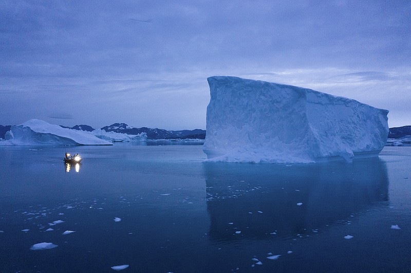 FILE - In this Aug. 15, 2019, file photo, a boat navigates at night next to large icebergs in eastern Greenland. As warmer temperatures cause the ice to retreat the Arctic region is taking on new geopolitical and economic importance, and not just the United States hopes to stake a claim, with Russia, China and others all wanting in. (AP Photo/Felipe Dana, File)
