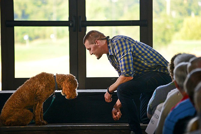 Brandon McMillan, host of CBS TV show "Lucky Dog," teaches Molly, a 4-year-old miniature golden doodle, the "leave it" command during the Court Appointed Special Advocates' "Brandon McMillan Live!" event at Capital Bluffs Event Center. The event served as a fundraiser while McMillan, who also trained CASA's courtroom therapy dog and mascot, Olive, gave insight into his training experience and techniques as he recorded his show in front of a live audience.