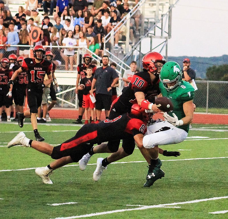 Blair Oaks sophomore Reid Dudenhoeffer has a pass broken up by a pair of Southern Boone defenders during Friday night's Jamboree at the Falcon Athletic Complex in Wardsville.